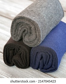 A set of gray, blue and black socks, rolled up for storage