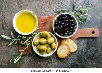 A set of Green and black olives and olive oil on a dark stone background, top view - Shutterstock ID 1487320037