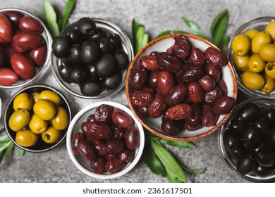 A set of green, red and black olives on a marble background. Various types of olives in bowls and fresh olive leaves. Vegan. Olive fruits. Place for text. Copy space. - Powered by Shutterstock