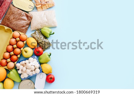 Set of grocery items from canned food, vegetables, cereal on blue background. Food delivery concept. Donation concept. Top view. Copy space
