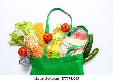 Set Of Grocery Items From Vegetables, Canned Food, Pasta, Oil, Cereal In Green Eco Shopping Bag On White Background. Top View.