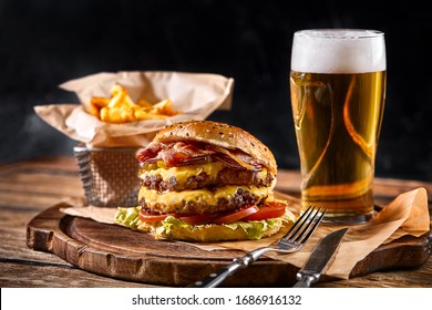 Set of hamburger beer and french fries. A standard set of drinks and food in the pub, beer and snacks. Dark background, fast food. Traditional american food. - Powered by Shutterstock