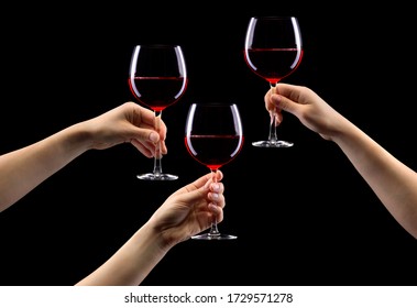 Set Of Hands Holding Red Wine Glass Isolated On Black Background.