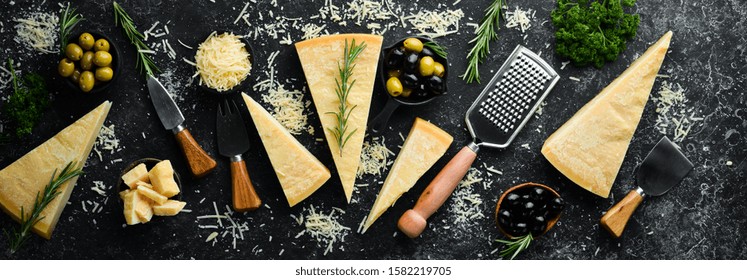 Set of hard cheeses with cheese knives on black stone background. Parmesan. Top view. Free space for your text. - Powered by Shutterstock