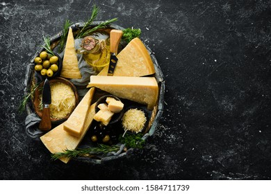 Set of hard cheeses with cheese knives on black stone background. Parmesan. Top view. Free space for your text. - Powered by Shutterstock