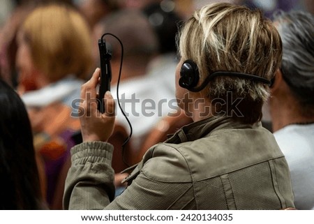 a set of headphones for simultaneous translation during negotiations in foreign languages. woman headphones used for simultaneous translation equipment simultaneous interpretation	