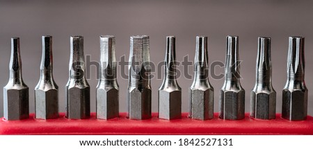 Set of heads for screwdriver, tools collection on red table.