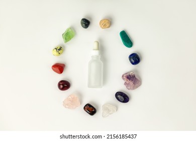 Set Of Healing Gemstones Crystals And Glass Bottle For Making Elixir In White Background, Top View. Crystal Therapy Concept