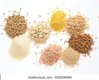 Set of heap various grains and cereals - raw green buckwheat, semolina, oat flakes, millet, brown rice, buckwheat or kasha,quinoa, and red rice.Isolated on white with clipping path.Top view.Copy space