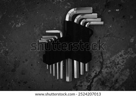 A set of hex keys in a black case on a gray concrete background