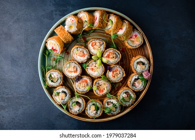 set hot sushi rolls fried in a round tray. Assortment of delicious tempura and baked sushi maki with salmon, eel, cucumber, avocado, scrambled eggs, shrimp. Japanese oriental cuisine - Powered by Shutterstock