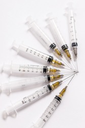 Set Of Hypodermic Plastic Syringes On White Background With Exposed Needles.