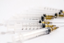 Set Of Hypodermic Plastic Syringes On White Background With Exposed Needles.