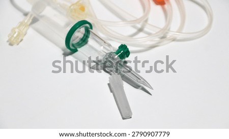 a set of infusion needle tools. An infusion set is also known as an IV set or infusion tubing. More specifically, this model is similar to the Intrafix Safeset series. It is used to deliver medical fluids, nutrients, or medications directly into a patient's bloodstream through a vein (intravenously) in controlled amounts and over a controlled period of time.
