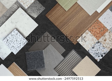 set of interior material sample in top view contains terrazzo stones, tiles, wooden laminated, glass, marbles placed on black marble table. interior mood and tone samples board.