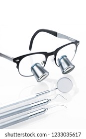 Set Of Isolated Professional Dentist Medical Equipment Tools And Surgical Loupe In Dental Office. Dental Hygiene And Health Conceptual Image.