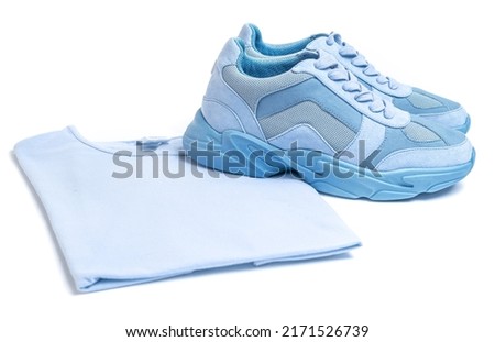  Set of items for sports - Light blue sneakers and t-shirt on a white background.