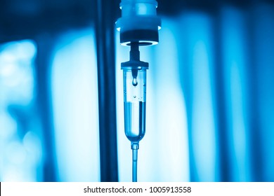 Set iv bag fluid intravenous drop saline drip slow in hospital room,Medical Concept,treatment emergency and injection drug infusion care chemotherapy, concept.blue light background,selective focus 
