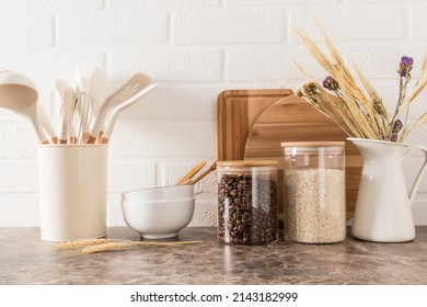 A Set Of Kitchen Utensils On A Dark Marble Countertop Against A White Brick Wall. Interior Background Of The Kitchen