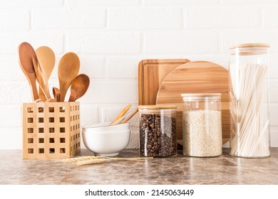 A Set Of Kitchen Utensils On A Dark Marble Countertop Against A White Brick Wall. Interior Background Of The Kitchen