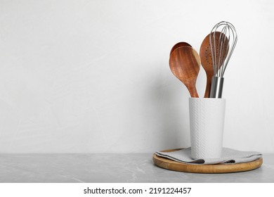 Set of kitchen utensils on light grey marble table. Space for text