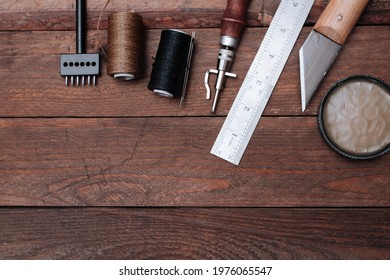 Set of Leather crafting tools. Shoes maker tools on wooden table. - Powered by Shutterstock