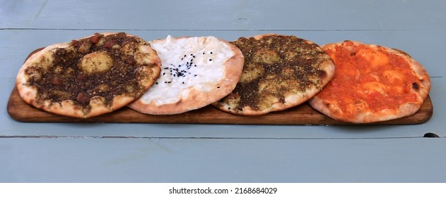 A set of Lebanese maouajanet or manaqish, zaatar, cheese, and lahm b ajin.