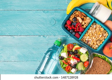 Set Of Lunch Boxes With Food Ready To Go For Work Or School. Greek Salad, Sandwich, Vegetables, Granola, Nuts, Berries, Eggs And Yogurt. Meal Preparation Or Dieting Concept. Top View With Copy Space