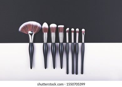 Set Of Makeup Brushes On Black And Grey Color Block Background. Minimal Concept. Flat Lay, Top View.