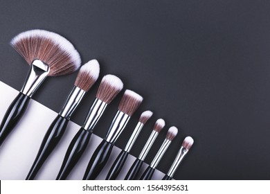 Set Of Makeup Brushes On Black And Grey Color Block Background. Minimal Concept. Flat Lay, Top View.