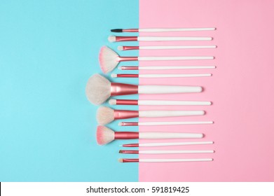 Set Of Makeup Brushes On Pink And Aqua Colored Composed Background. Top View Point, Flat Lay.