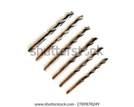 Set of masonry drill bits in various sizes, isolated on white background. Steel twist bits for concrete, brick, and stone drilling in construction, hardware retail, and DIY home renovation.
