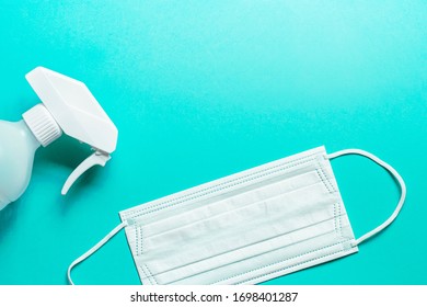 Set Of Medical Mask And Antiseptic Solution On Blue Background And Copy Space.