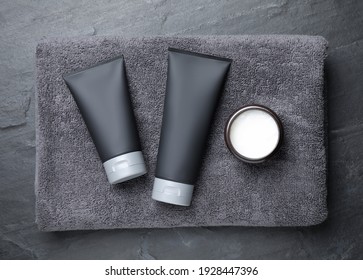 Set of men's cosmetic products with towel on grey stone table, top view