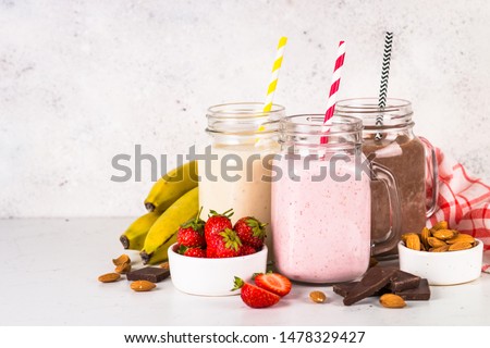 Set of milkshake in mason jars. Banana, chocolate and strawberry milkshakes. Summer dessert. Healthy food.