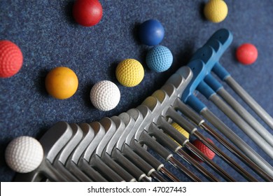 Set Of Mini Golf Clubs And Color Balls On Blue Covering