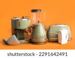 Set of modern household appliances on orange background