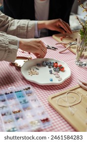 Set of multi-colored ceramic and plastic beads for needlework, child and mother are making jewelry at home. Easy and creative craft for children and teenagers. Making bracelets or necklace DIY