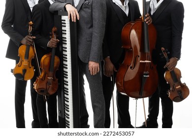Set of musical instruments: violin, cello, piano in the hands of the musicians.
