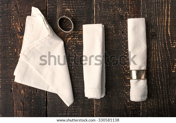 Set\
of the napkins with vintage ring on the wooden\
table