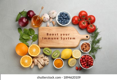 Set of natural products and wooden board with text Boost Your Immune System on grey table, flat lay - Shutterstock ID 1894620109