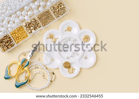 Set of for needlework and beading with tools for making jewelry. Handmade pearls beaded jewelry and different beads in boxes. DIY art activity. Creativity and  hobby.