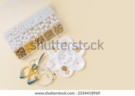 Set of for needlework and beading with tools for making jewelry. Handmade pearls beaded jewelry and different beads in boxes. DIY art activity. Creativity and  hobby.