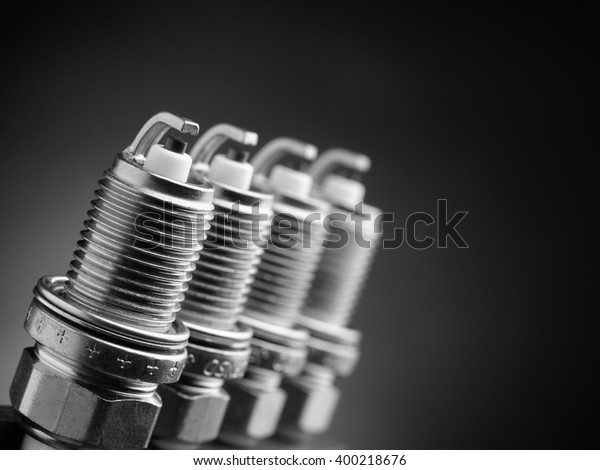 A set of new spark plugs of the car, and\
spare parts of vehicles on a dark background. Studio macro image of\
high quality. To advertise auto\
service.