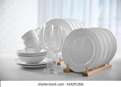 Set of new white dishes on wooden table, indoors