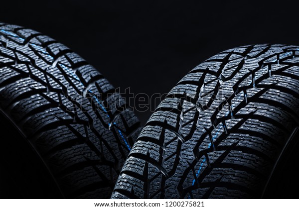 Set of new
winter tires on black background with contrasty lighting. Close up
product photograph of unused
tyres