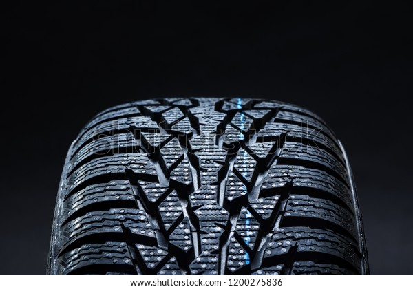 Set of new\
winter tires on black background with contrasty lighting. Close up\
product photograph of unused\
tyres