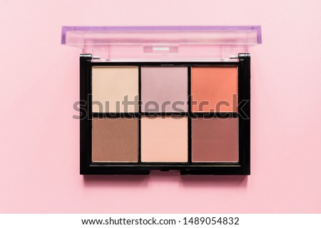Set of nude eyeshadows in black case on pink background. Top view , copy space