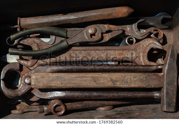 \
set of old rusty construction tools in a rusty old\
box
