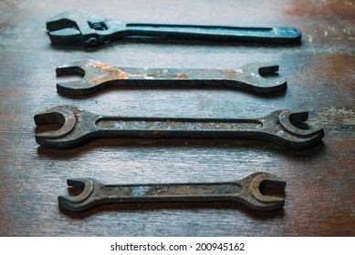 Set of old rusty wrenches on wooden surface